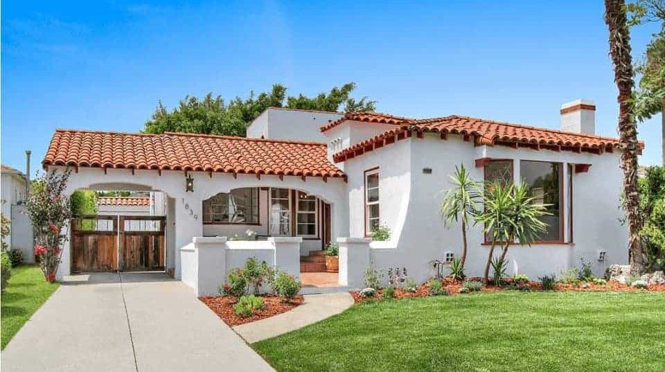 light terracotta and white house with garden in front of it